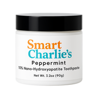 Jar of Smart Charlie's peppermint toothpaste with a black lid on a white background