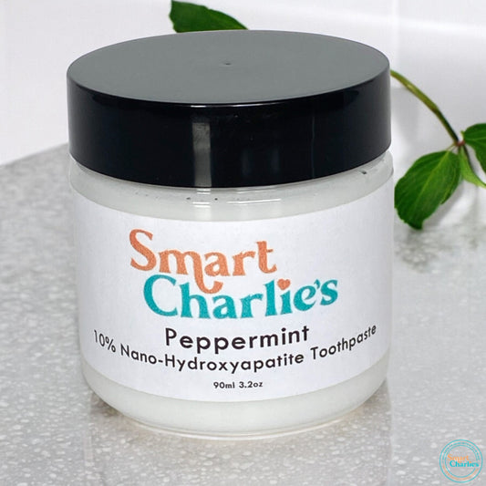 Jar of Smart Charlie's peppermint toothpaste with a black lid on a white background